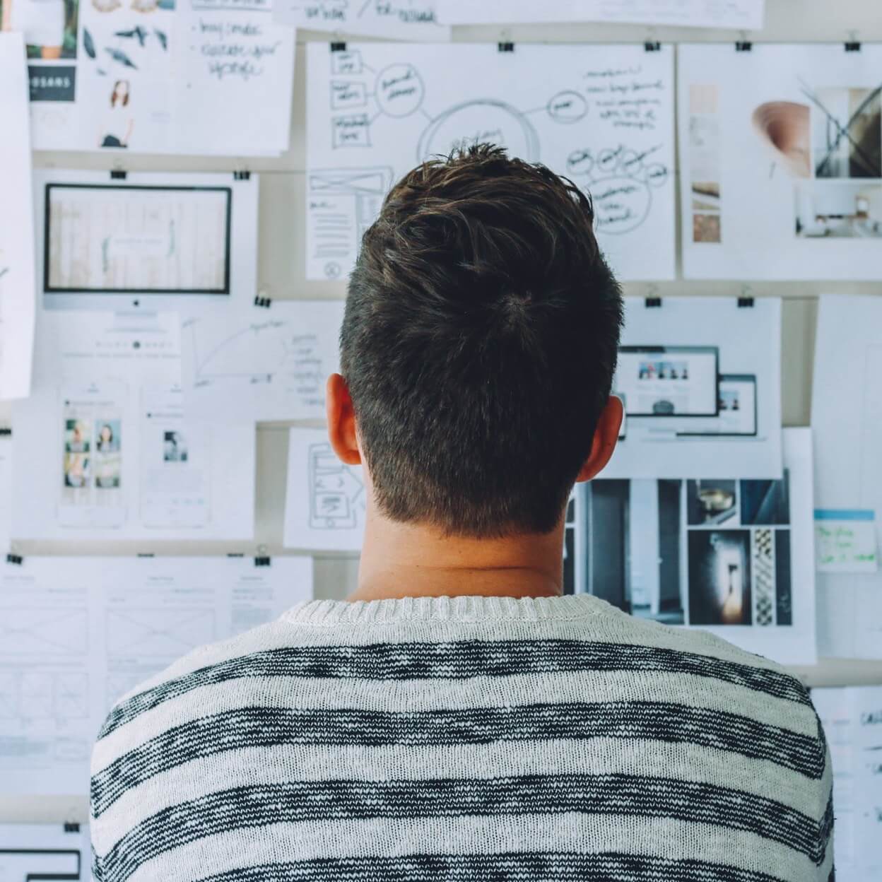 Person looking at wall covered in paper